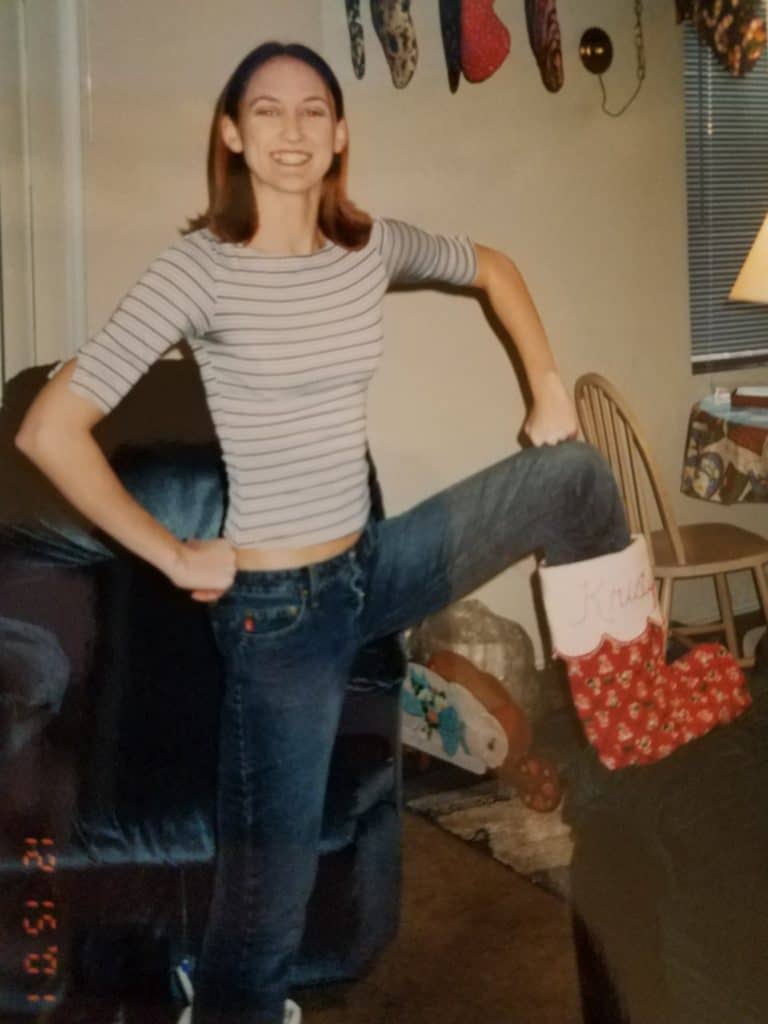 College age white woman posing with a stocking on her foot.