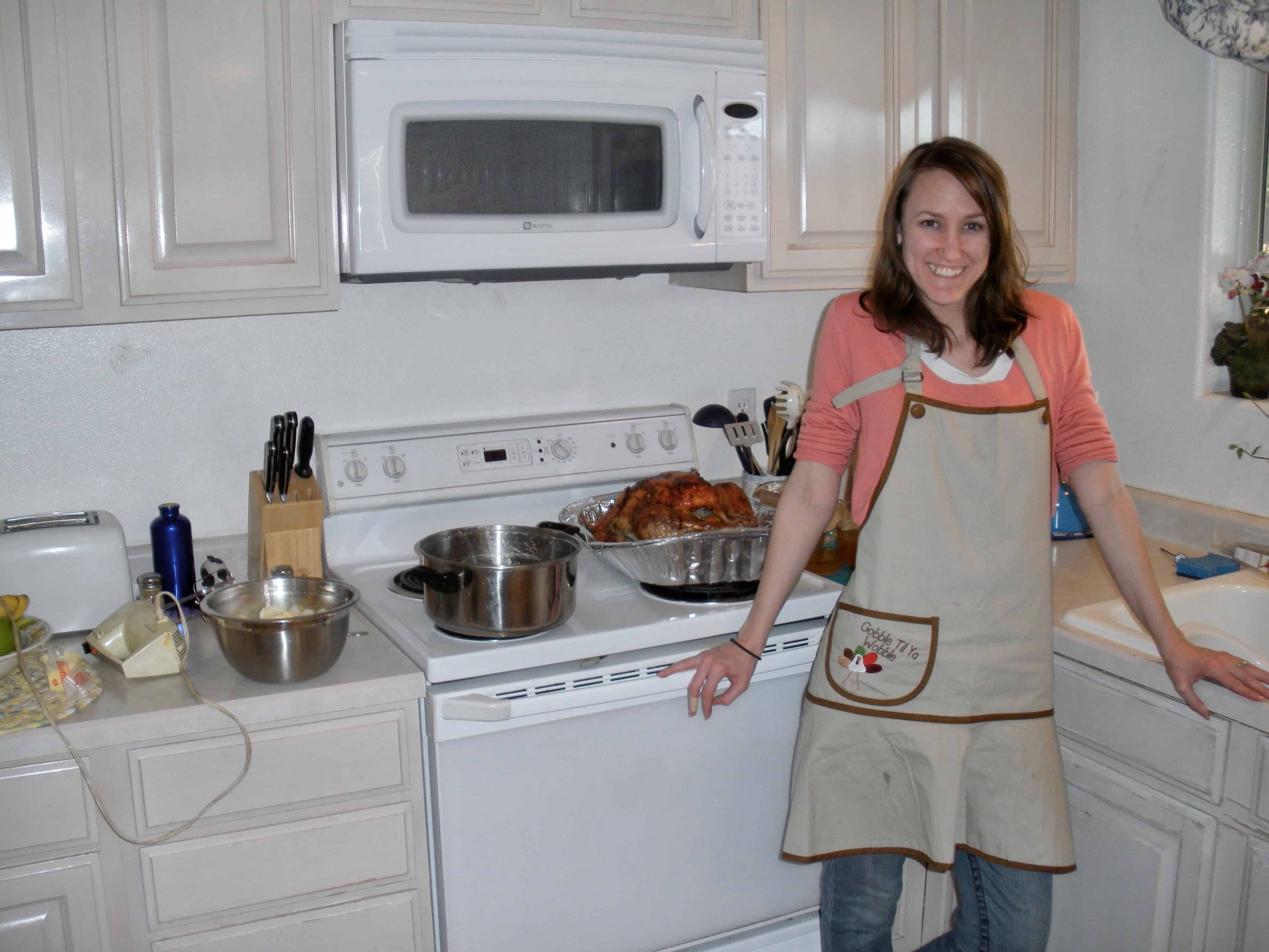 Young white woman in apron making Thanksgiving dinner.