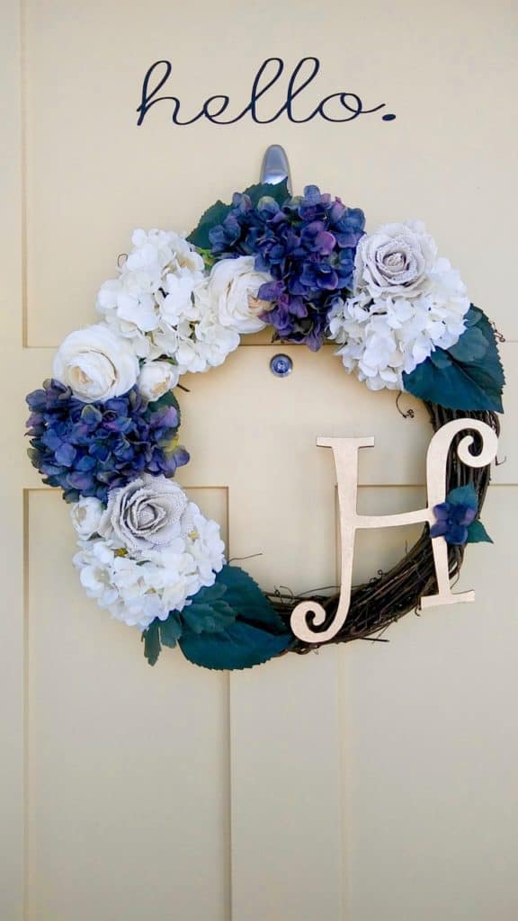 Floral Spring wreath hanging on a pale yellow door.