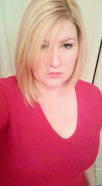 Selfie of caucasian woman in her 30's  with bleached blonde hair and wearing a hot pink v-neck.