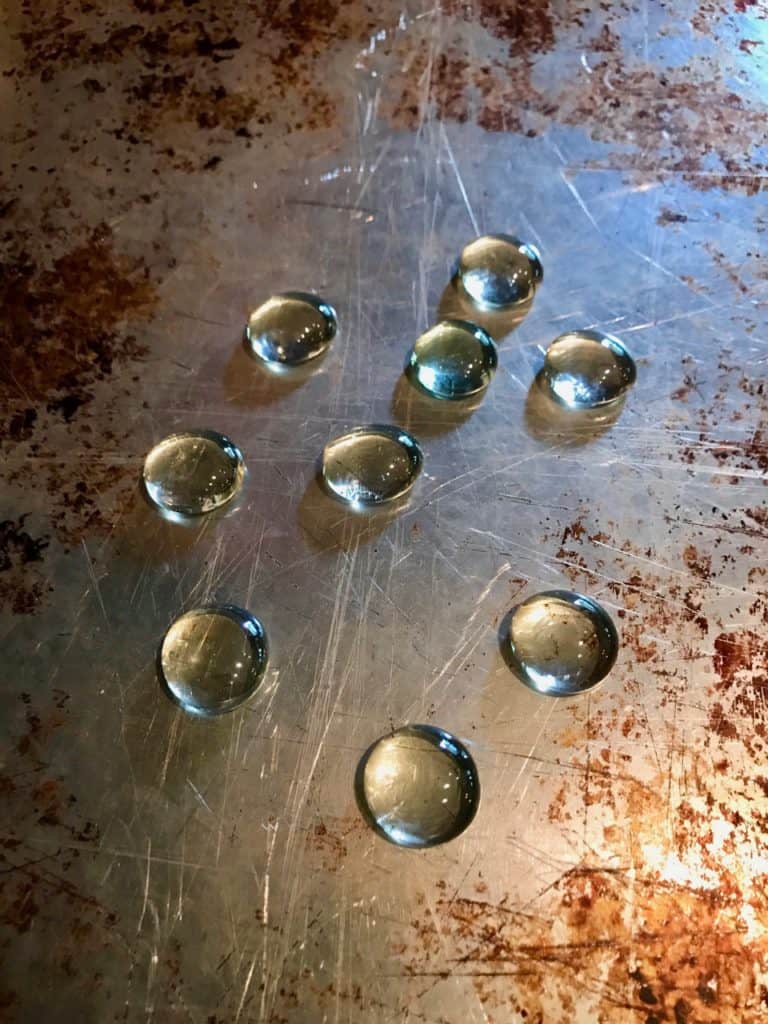 clear, fat glass marbles laying on a baking sheet