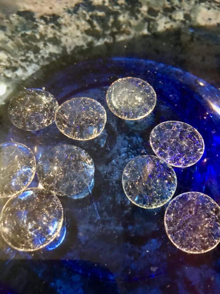 A bunch of flat glass marbles with cracks in them.