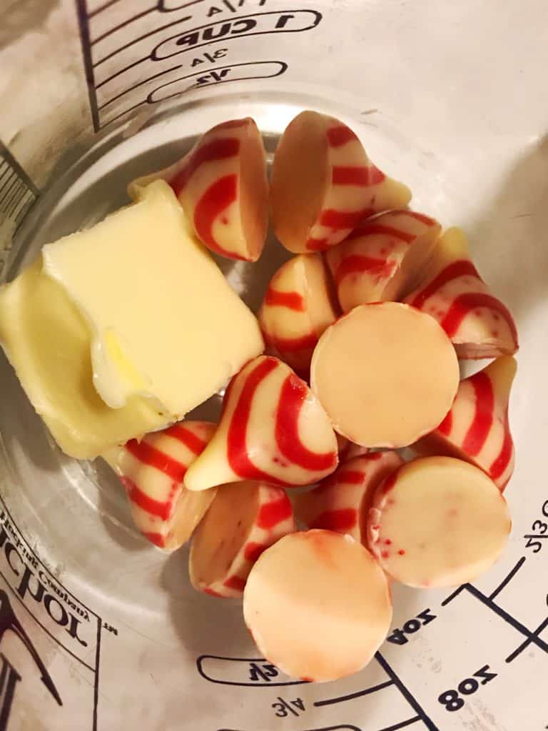 Unwrapped holiday Kisses and butter in a clear pyrex measuring cup