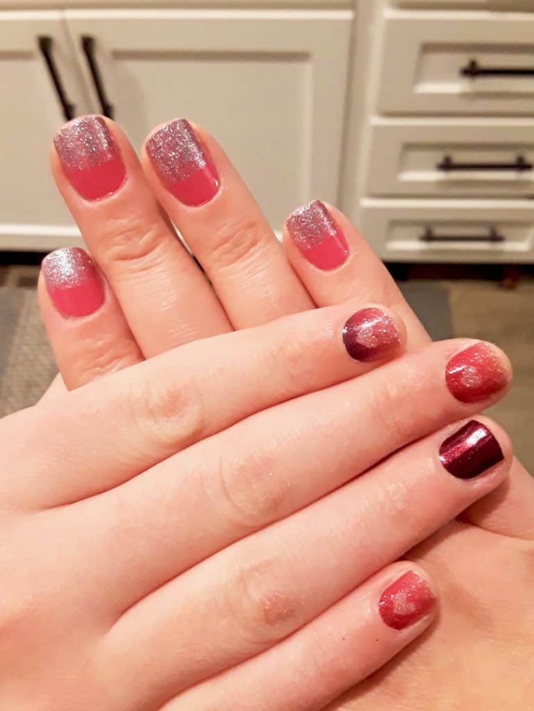 Mom and daughter manicures using Color Street nail strips. A coral color with glitter tips.