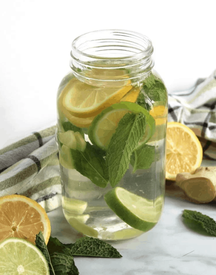 Flavored Water with Lemon, Mint, and Ginger is a refreshing way to stay hydrated this Summer. Check out this recipe and 16 other Flavored Water Recipes by clicking the link! | We Three Shanes