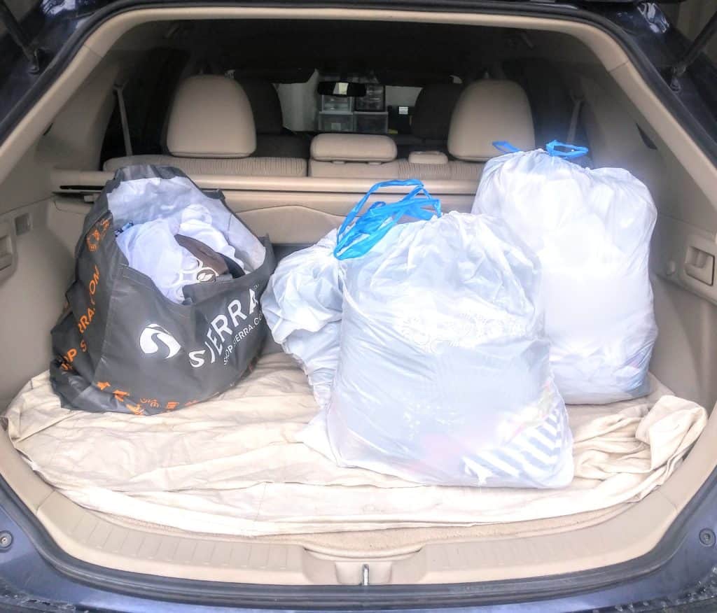 4 Trash bags full of decluttered items in the back of a car, ready to go the thrift store.