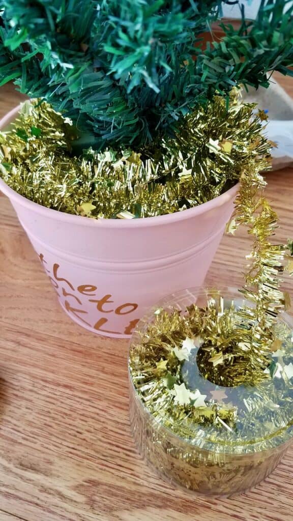 Adding some gold tinsel to this Dollar Store Christmas tree for a little girl or tween bedroom. | We Three Shanes