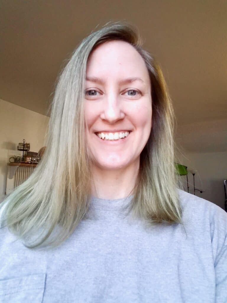 Photo of me (Caucasian with collar bone length, straight hair) after using Overtone Vibrant Silver. Hair looks to be ashy blonde in color with some light gray at the ends of hair. | We Three Shanes