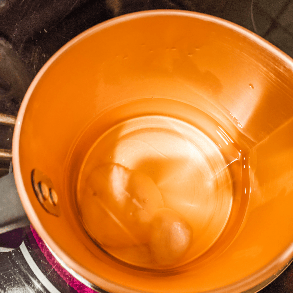 Soy wax almost melted in copper candle making pouring pot.