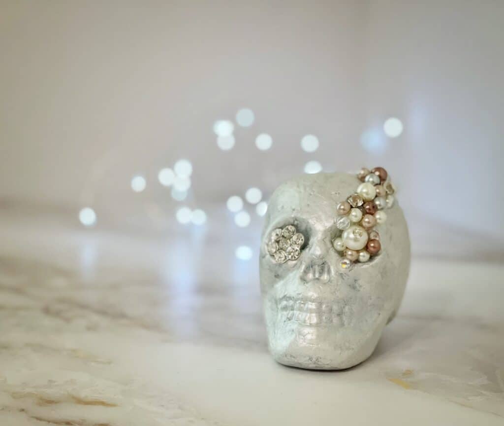 White foam skull head with pearls and bling glued to it.