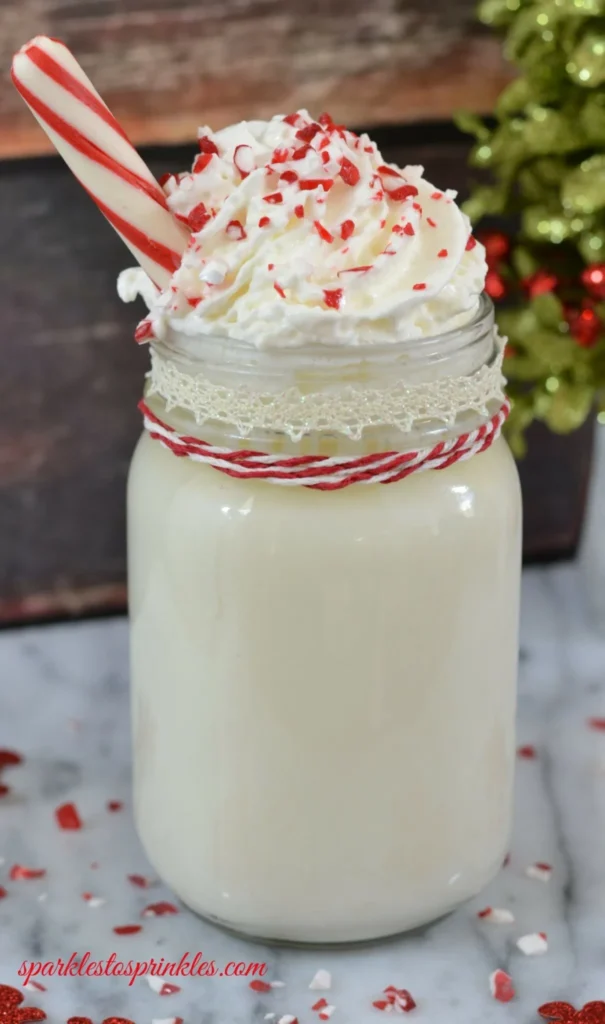 White hot chocolate in a mason jar, topped with whipped cream and crushed candy cane