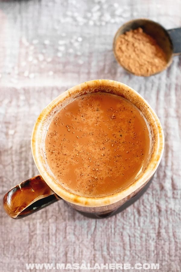 orange-brown drink in a brown mug.