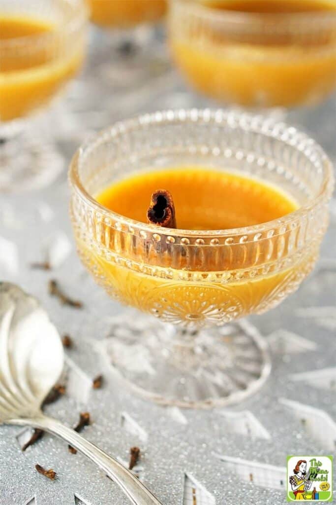 Fancy crystal goblet with orange drink and a cinnamon stick.