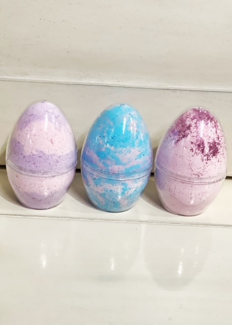 three egg shaped bath bombs in their mold.  Pink and purple on the far left, blue and pink in the middle and pink with pink glitter to the far right. | wethreeshanes