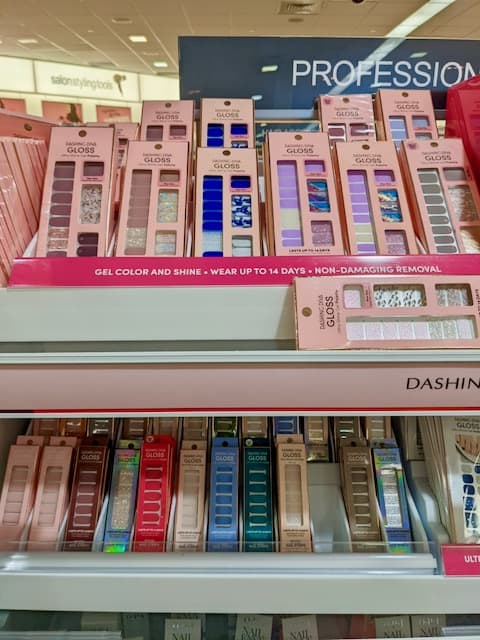 Packages of Dashing Diva Nail Sets on display at Ulta Beauty. Two rows of  6 on the top shelf. Two rows of twelve smaller sets on the bottom row.