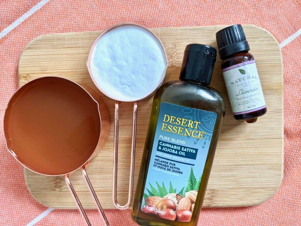 DIY Apple Cider Vinegar Foot Soak ingredients - 1/2 cup apple cider vinegar, 1/4 cup of baking soda, a bottle of jojoba oil, a bottle of lavender essential oil.