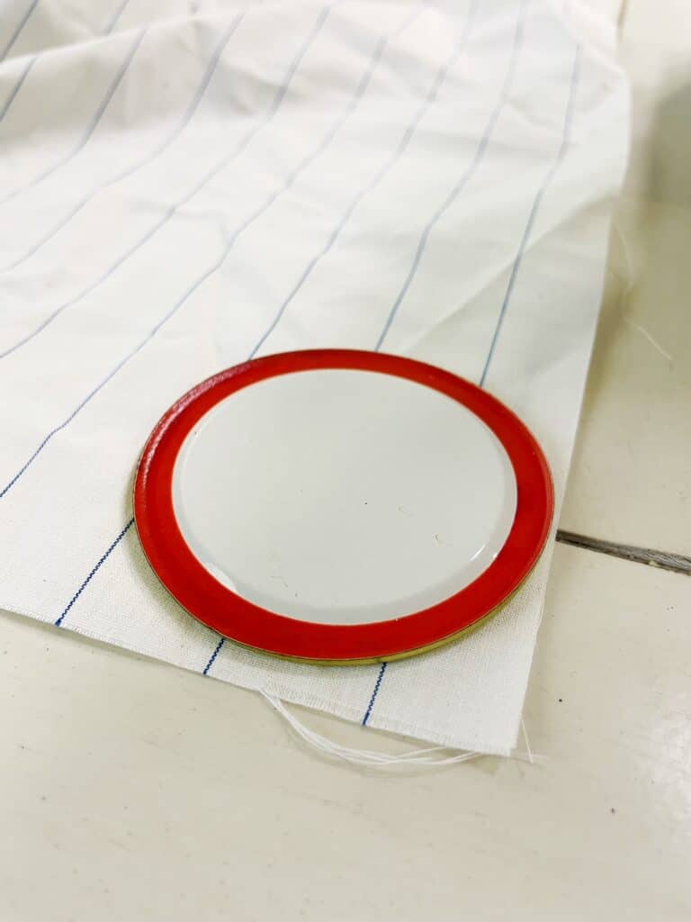 a piece of fabric with a piece of round metal sitting on top of it 