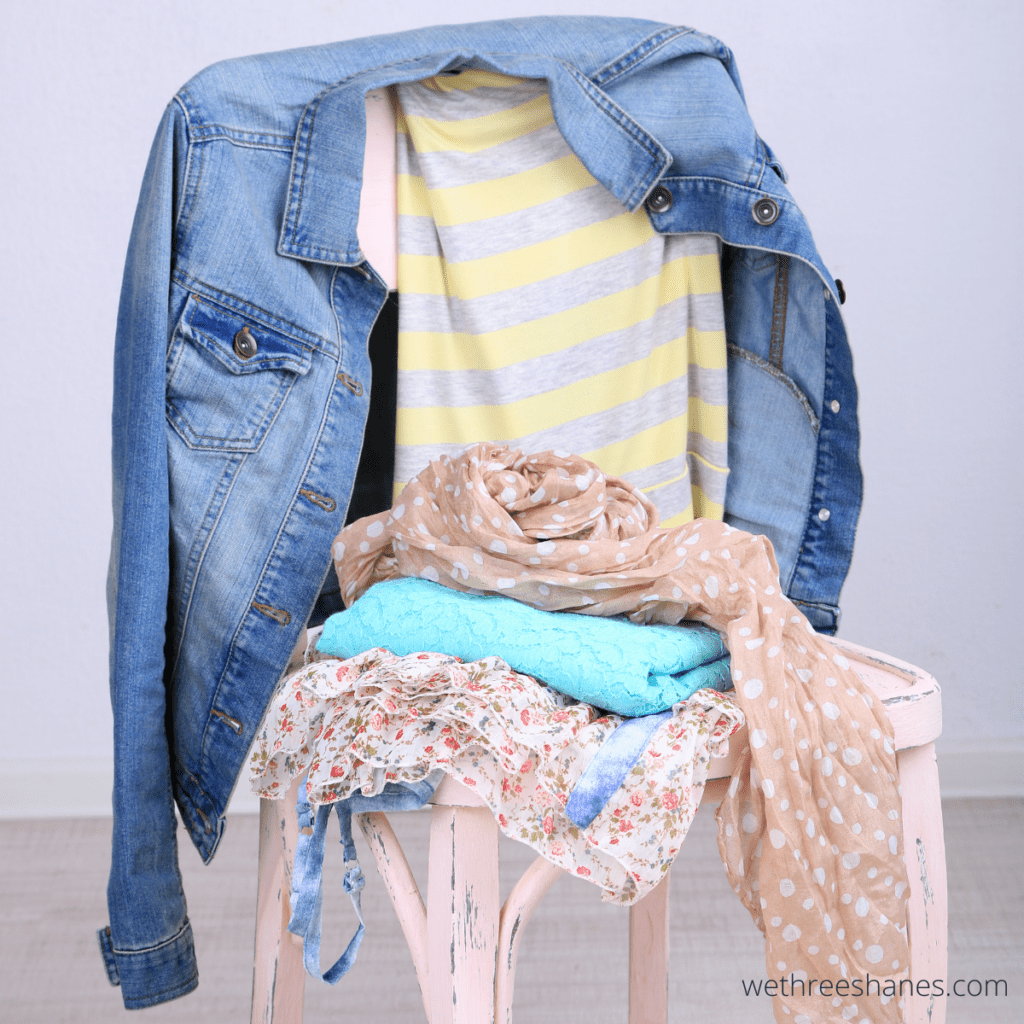 A chair stacked with laundry in the bedroom that needs to be decluttered.