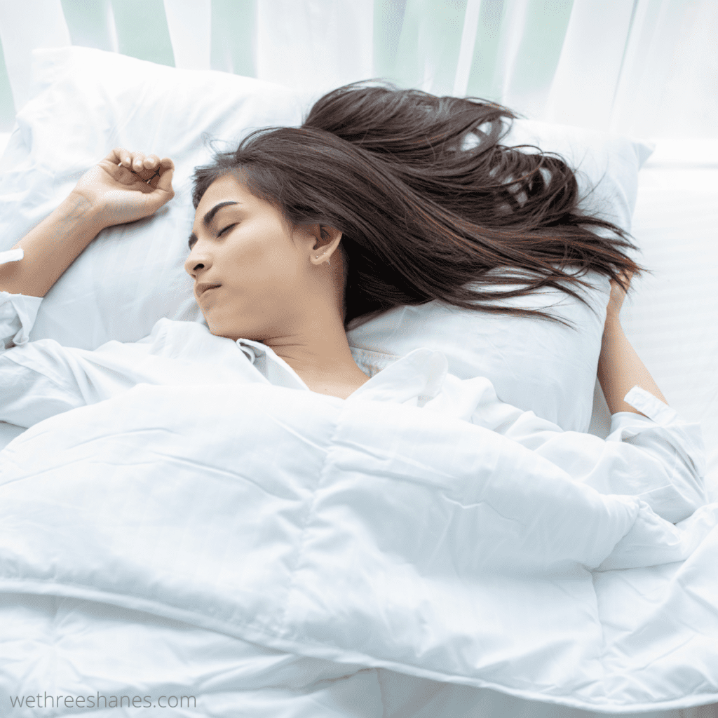 Women sleeping well in a comfortable bed in her decluttered bedroom.