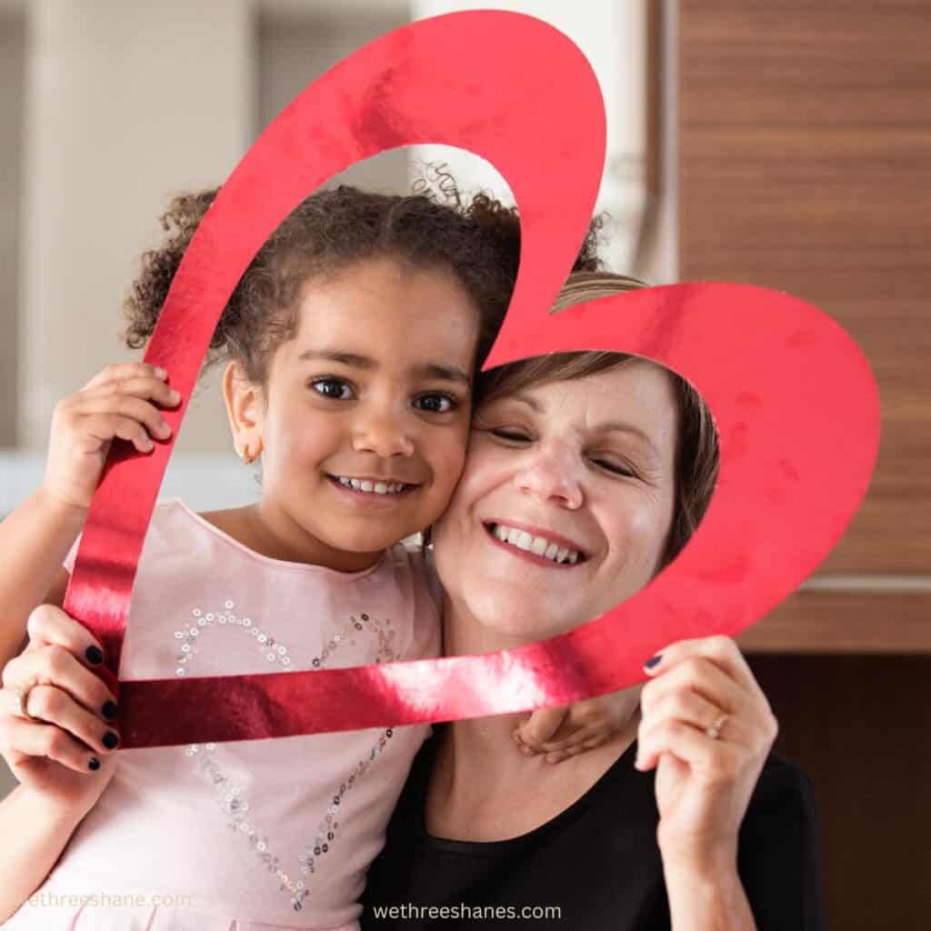 Mom and daughter having fun with a cut out heart on valentines day.