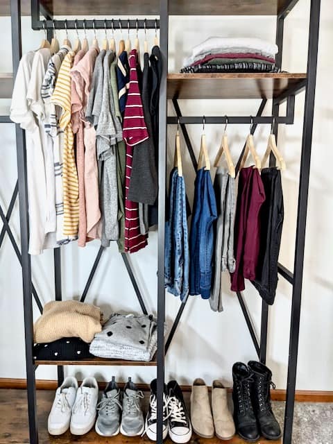 An example of a real capsule wardrobe that includes - 13 tops, 4 sweaters, 5 pair of jeans, 5 pair of joggers and wide leg pants, and 5 pair of shoes.