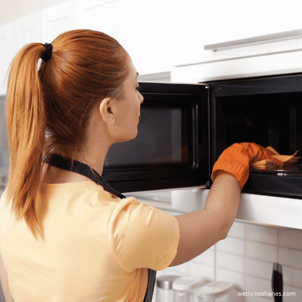 Female cleaning a microwave