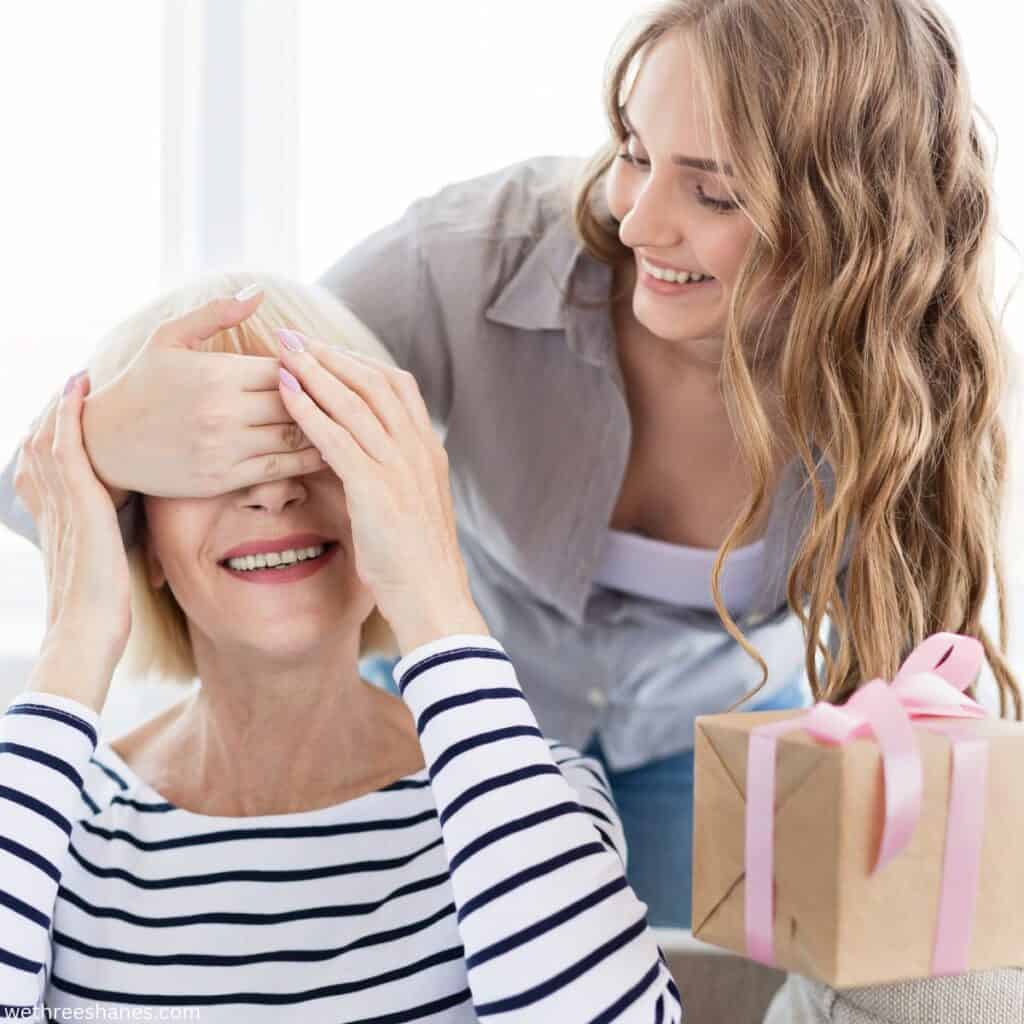 Young woman surprising older mom with a gift.