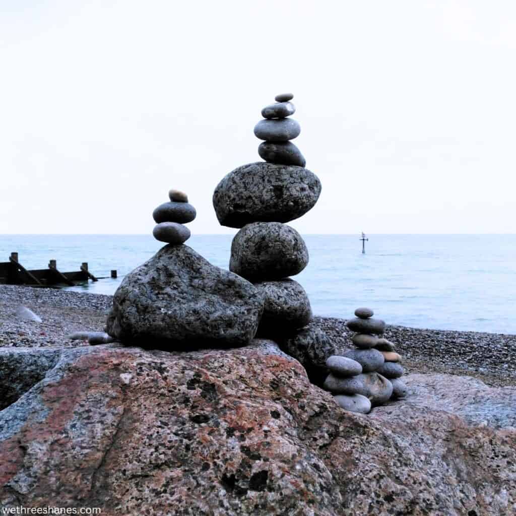 rocks stacked on top of each other to make towers at the beach