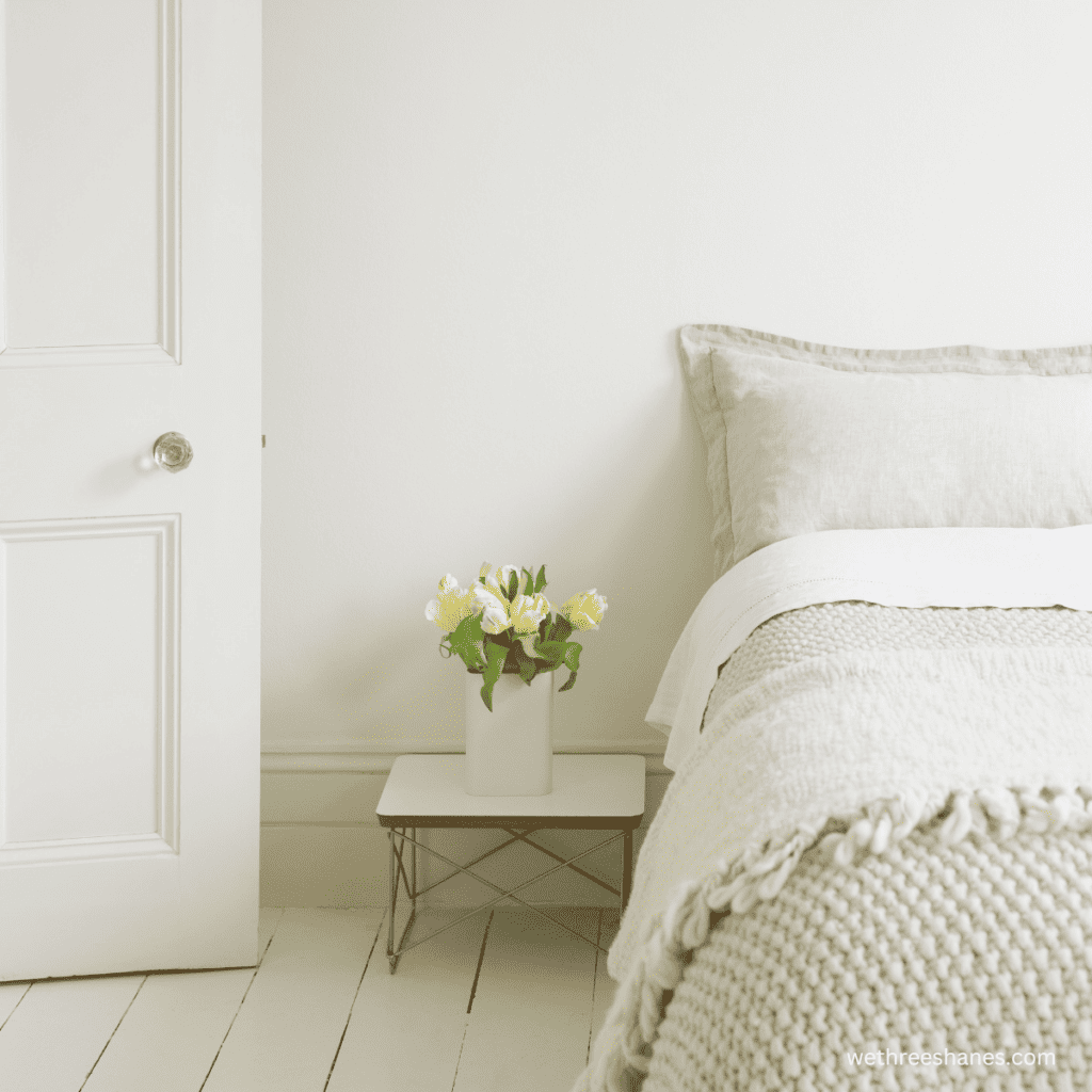 Fresh flowers bring warmth to this cozy minimalist bedroom.