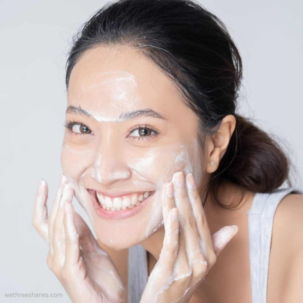 Woman washing her face as part of her minimalist skincare routine.